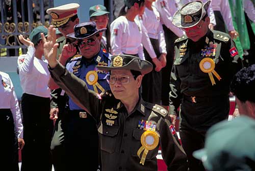 Unreal Politick: Khin Nyunt (center) and other Burmese generals pressing the cowered flesh in Tachilek in 1996. Once head of Burma’s notorious Military Intelligence (MI), Khin Nyunt is today (2004) considered a moderate in the ruling junta. 