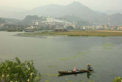 A view of Mogok, its lake (a former gem mine) and pagoda-covered mountains.