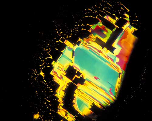 Figure 5.  Rectangular symmetry A fingerprint in a Sri Lankan sapphire. Here the fingerprint has formed along a prism face (parallel to the c axis), and so the healed (dark) areas show rectangular (90°) outlines, indicating the two-fold symmetry at right angles to the c axis. Photo © Richard W. Hughes