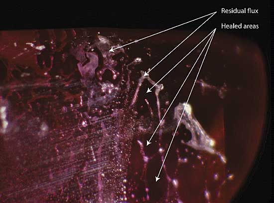 Figure 8. Residual flux Residual flux in a flux-healed fracture within a heat-treated Mong Hsu ruby. The areas (in the plane of the fracture) between the flux-filled channels consist of healed ruby. Photo: R.W. Hughes