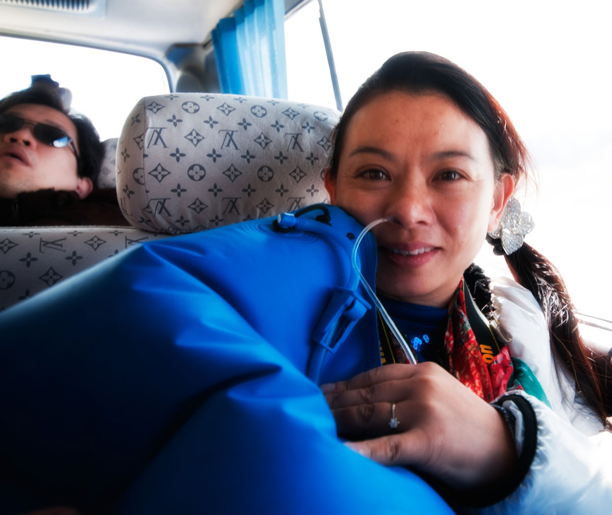 Figure 5. He Qiong breathes from an oxygen pillow near Shigatse, while Thanong Leelawatanasuk does his best to suck in a bit more air. At 3,840 m (12,600 ft), Shigatse is high enough that visitors who fly in from sea level (as our party did) are extremely susceptible to acute mountain sickness (AMS). Approximately half of our party suffered from AMS during the journey to Tibet's andesine mines. Photo: Richard W. Hughes