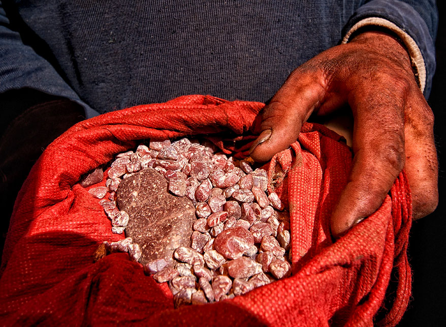 Figure 12. Handful of andesine near Zha Lin village, in Tibet's andesine mining district. Photo: Richard W. Hughes