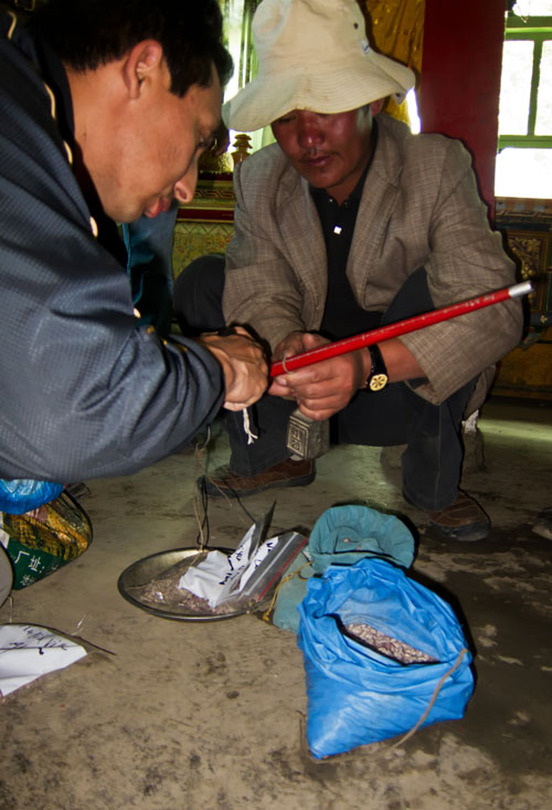 Figure 16. Ahmadjan Abduriyim and a Tibetan gentleman weighing up andesine purchases in Nai Sa village. We were told by the headman of this village that not only had he collected andesine since he was a child, but that his parents and grandparents had done the same. Thus it seems that andesine from Tibet has been collected for several generations. Photo: Richard W. Hughes