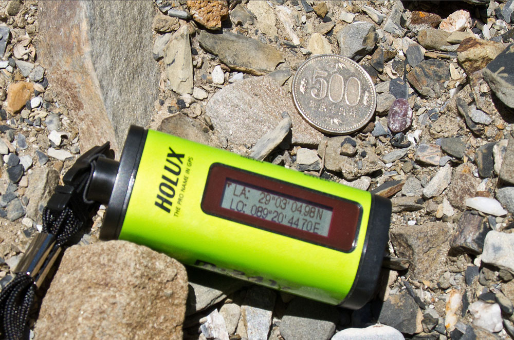 Figure 6. A "floater" of andesine just to the right of the coin in Upper Yu Lin Gu valley. Photo: Richard W. Hughes